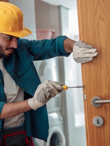 locksmith workman in uniform installing door knob 2023 01 05 00 20 11 utc